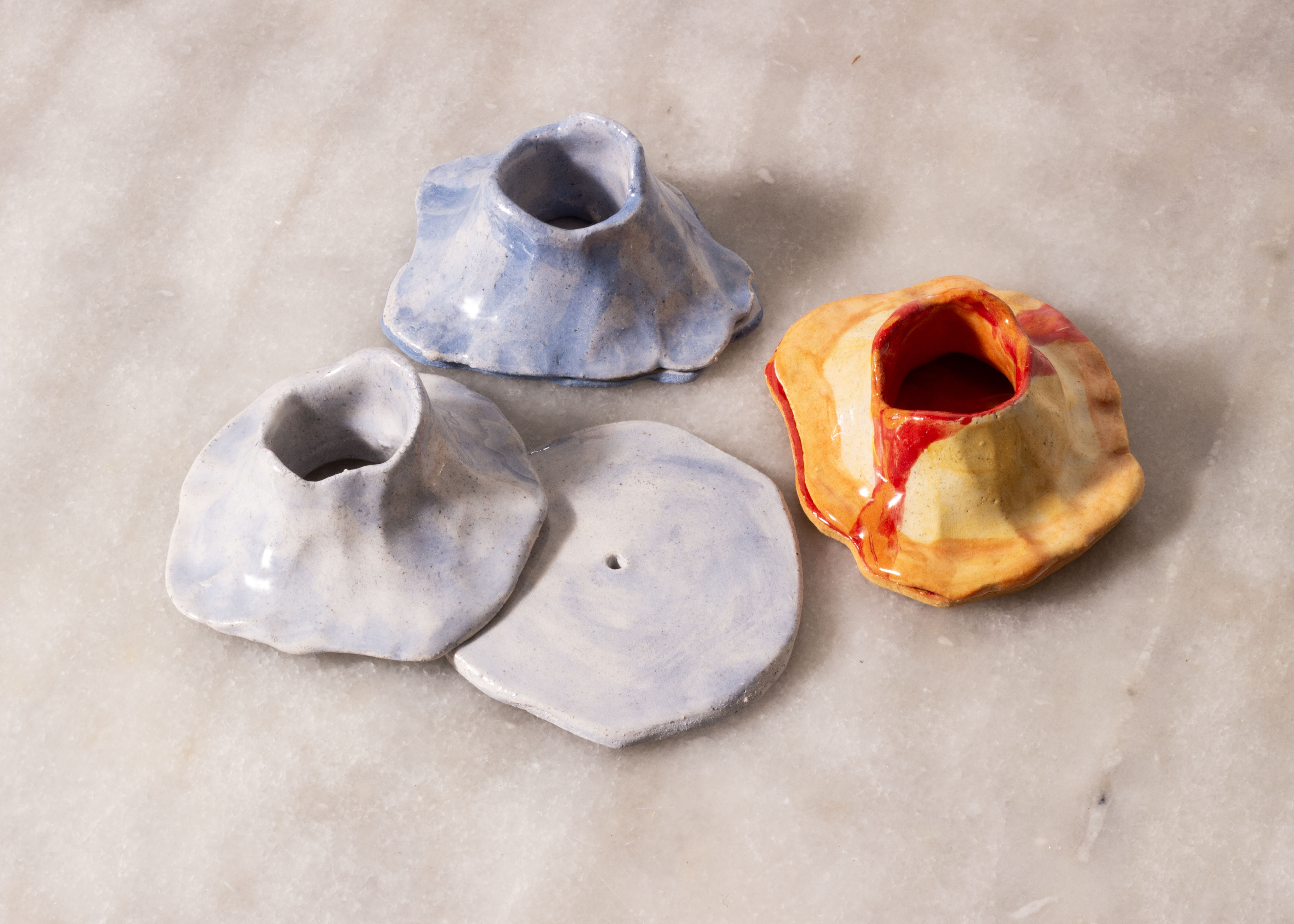 2 encensoirs bleus et un encensoir rouge, jaune et orange, en forme de volcans