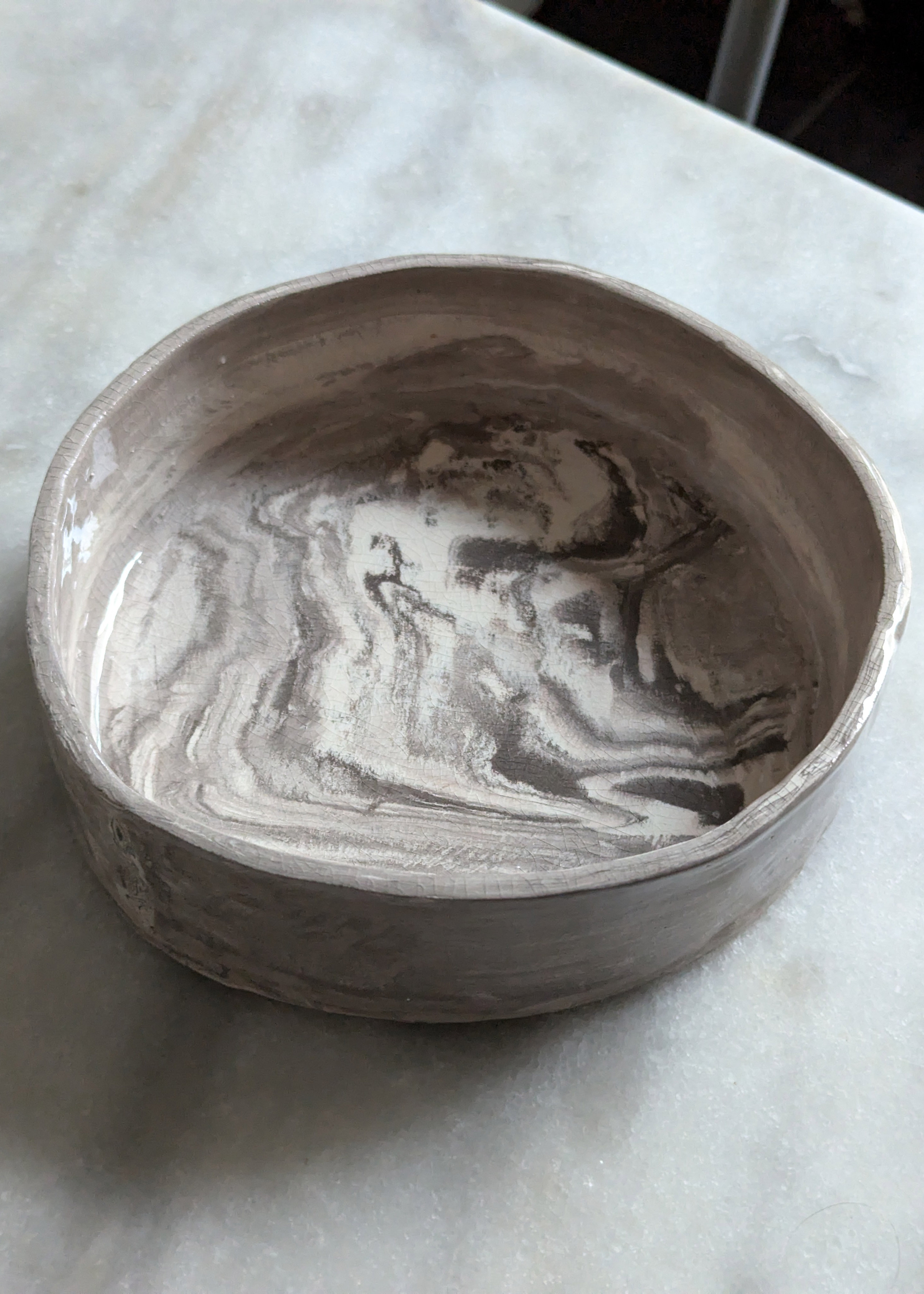  plat rond aux rebords droits, en terre brune et blanche, en marbrure